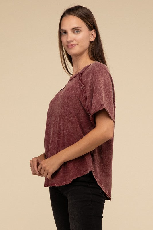 A person with long brown hair wearing a Back Patch Crinkle Washed Raglan Sleeve T-Shirt stands against a plain beige background.