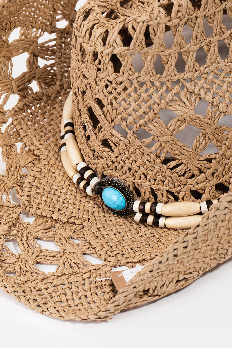 The Fame Cutout Strap Weave Straw Hat features a decorative straw strap weave, wooden beads, and a turquoise stone on the band—ideal for infusing a touch of rustic charm into your summer wardrobe or beach outings.