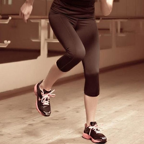 Person wearing dark-colored, form-fitting Capri Leggings Lauma Active Lady Fitness, perfect for average intensity workouts; shown from the waist down with legs and lower torso visible.