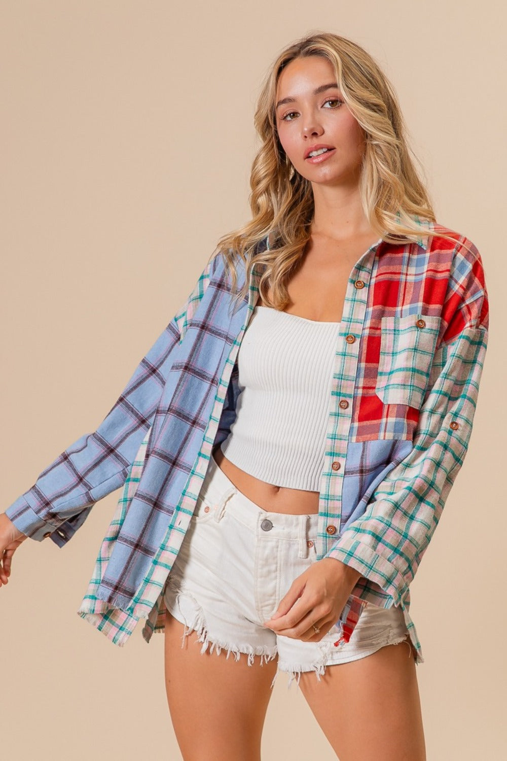 A person wearing a vibrant BiBi Color Block Plaid Button Down Shirt and white denim shorts stands against a neutral background.