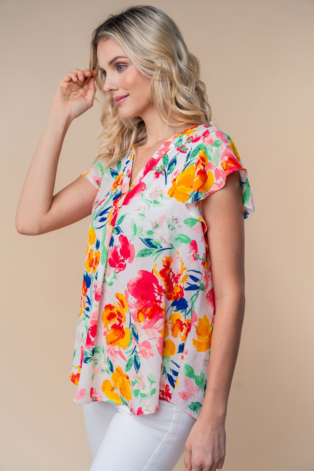 A woman wearing a White Birch Full Size Short Sleeve Floral Woven Top stands against a neutral background.