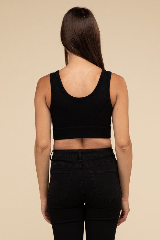 A person with long brown hair wearing the Ribbed Seamless Crop Top in light blue and black pants stands against a beige background, showcasing a perfect summer essential.