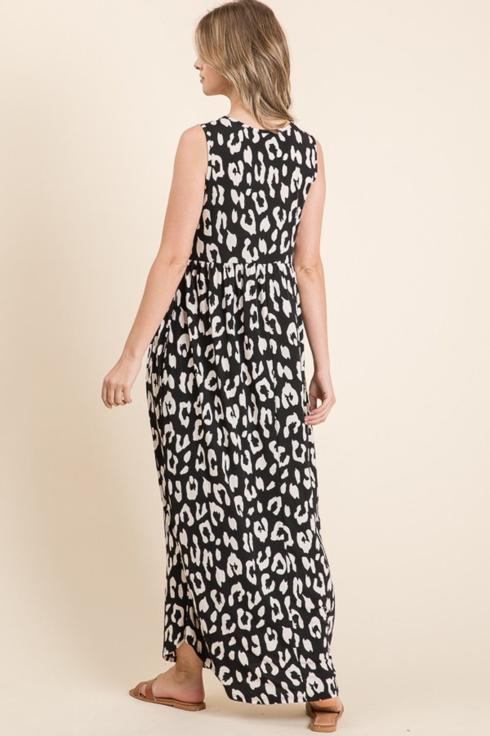 A person wearing the BOMBOM Leopard Maxi Dress with Pockets, paired with brown sandals, is standing against a beige background.