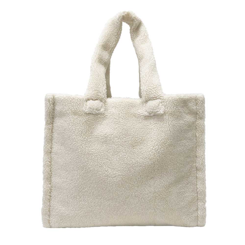 The Astrid Shopper Tote is a tote bag made from cozy blue teddy fleece. It showcases a straightforward rectangular shape with two sturdy handles and comes equipped with a zippered interior pocket for extra functionality.