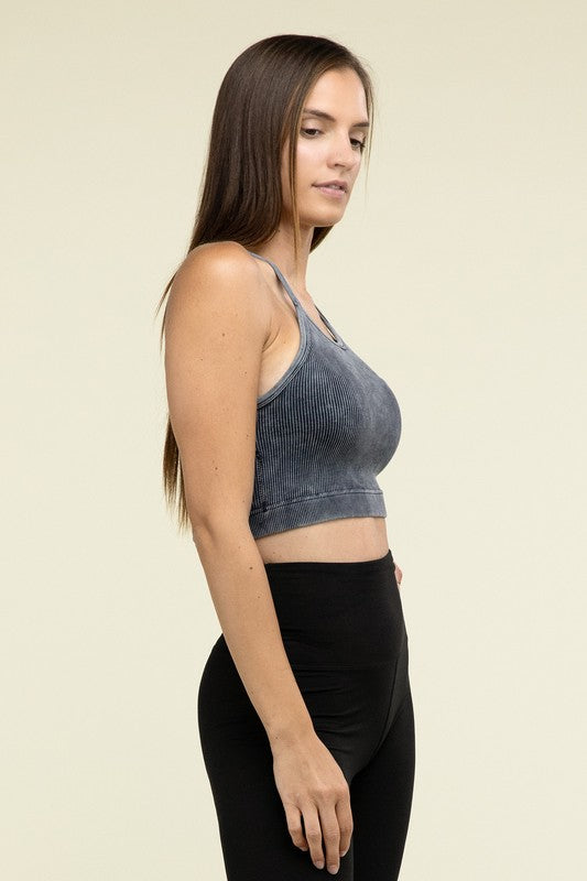 A person poses in a Washed Ribbed Seamless Cropped Cami Top with removable bra pads and black leggings against a neutral background.