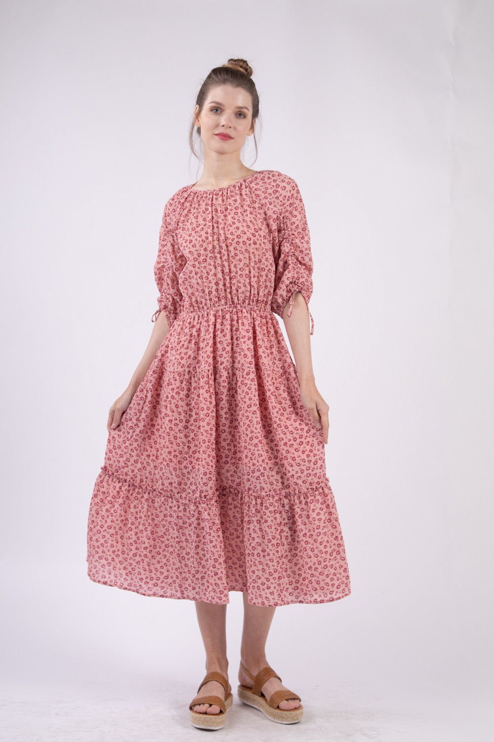 A woman wearing the VERY J Floral Round Neck Tiered Midi Dress and sandals poses gracefully against a plain white background.