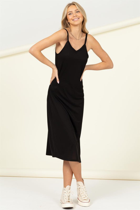 A person in the Make It Right Sleeveless Maxi Dress, known for its relaxed fit and pink hue, poses gracefully against a plain background.