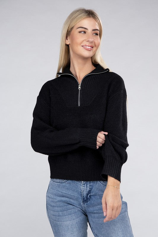 A person with long blonde hair wears a stylish cozy top—an Easy-Wear Half-Zip Pullover in grey—and blue jeans while looking down.