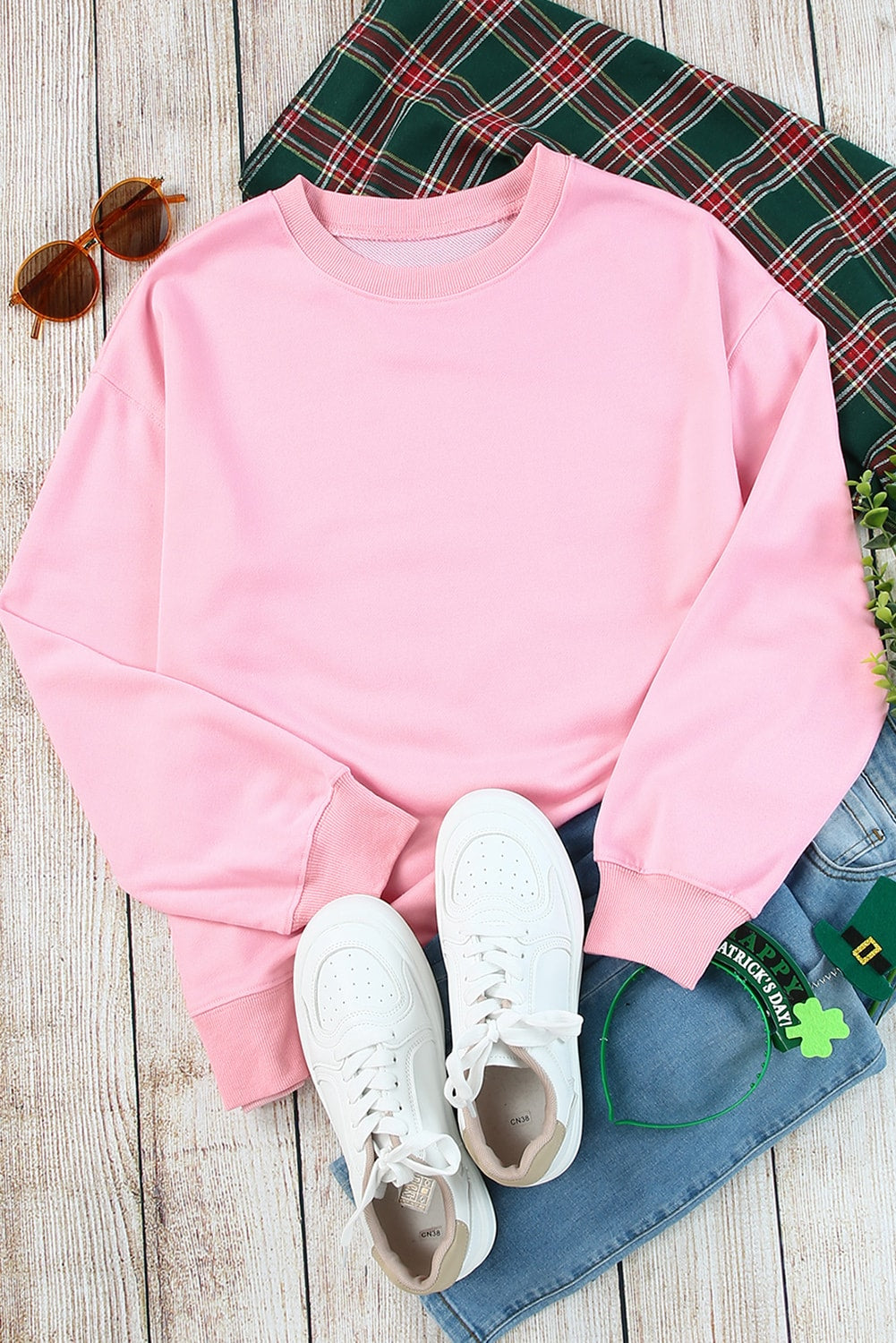 Individual with wavy brown hair wearing a Pink Plain Crew Neck Pullover Sweatshirt and blue jeans, standing with their back to the camera.