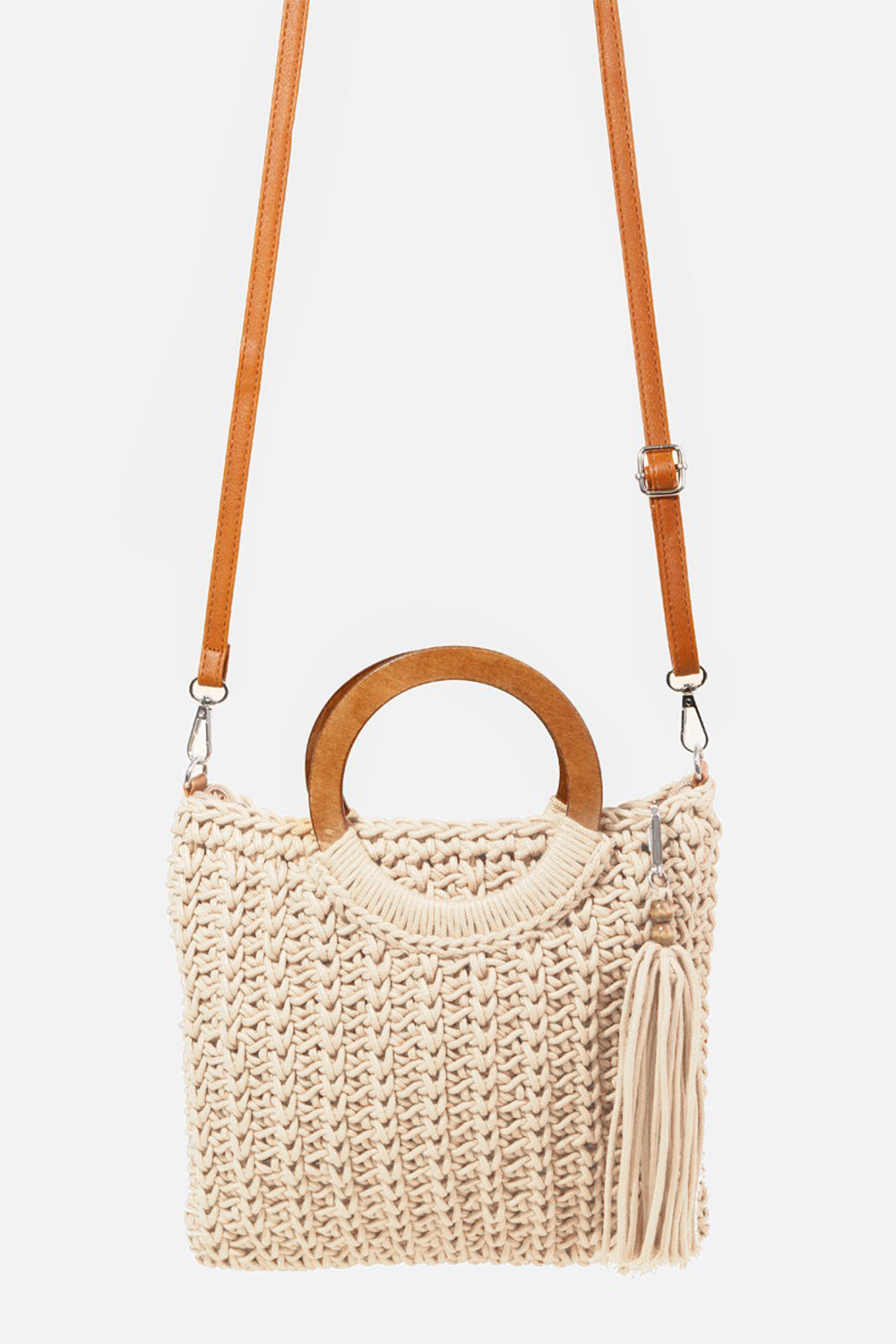 The Fame Crochet Knit Convertible Tote Bag includes a cream-colored design with round wooden handles and a matching tassel accent.