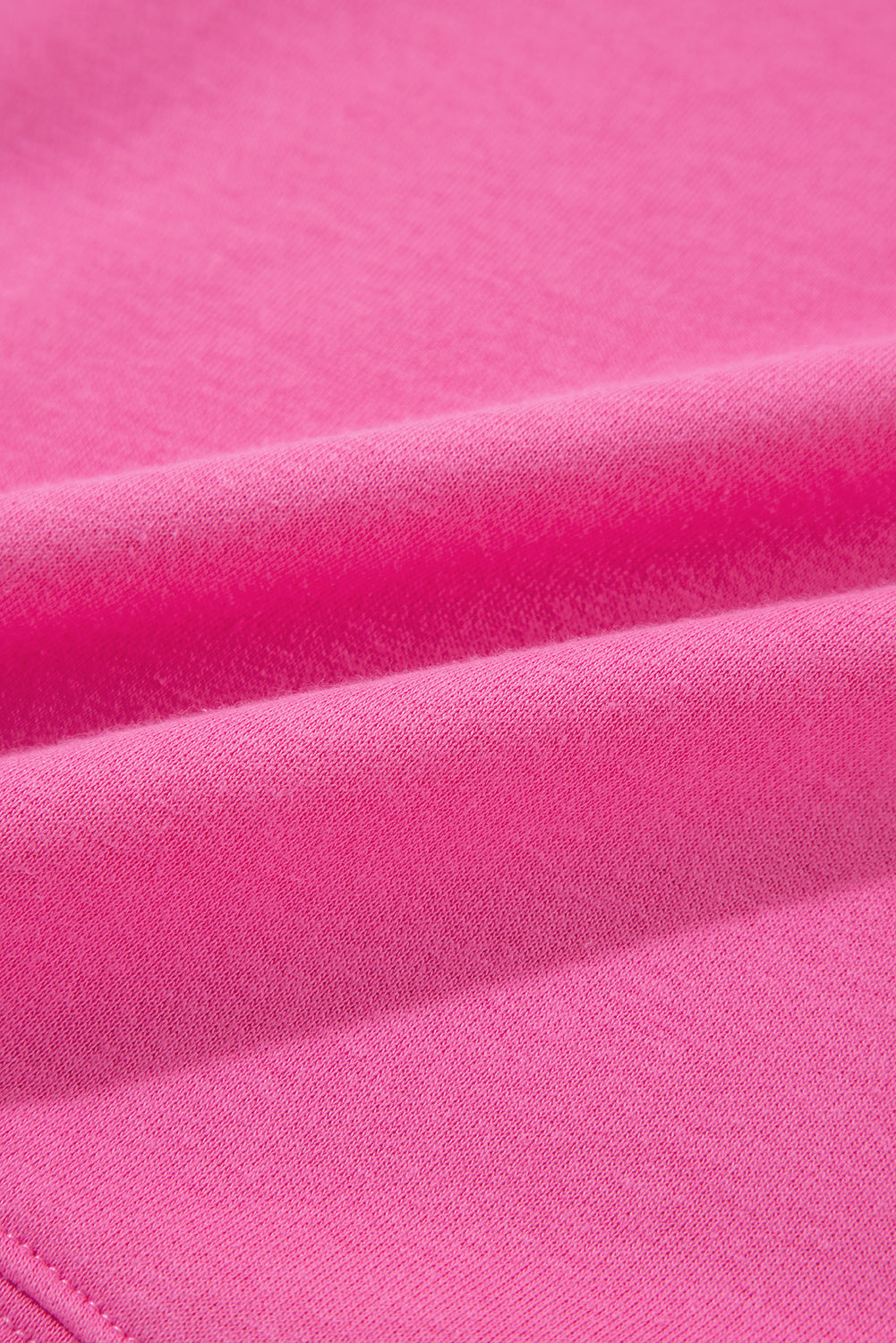 A person with long hair is seen from behind, wearing a Bright Pink Vintage Mineral Wash Half Button Collared Sweatshirt and light blue jeans.