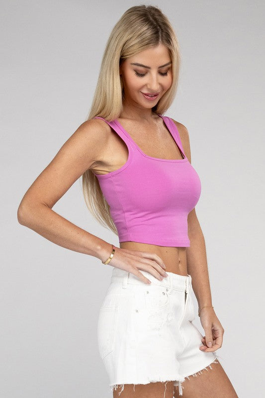 A woman with blonde hair smiling, wearing a Cotton Square Neck Cropped Cami Top and white pants, standing against a grey background.