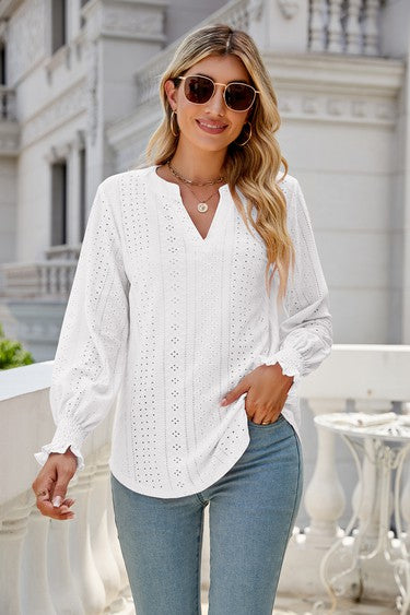 A woman wearing sunglasses, a light pink Women Long Sleeve TOP, and blue jeans stands on a balcony.