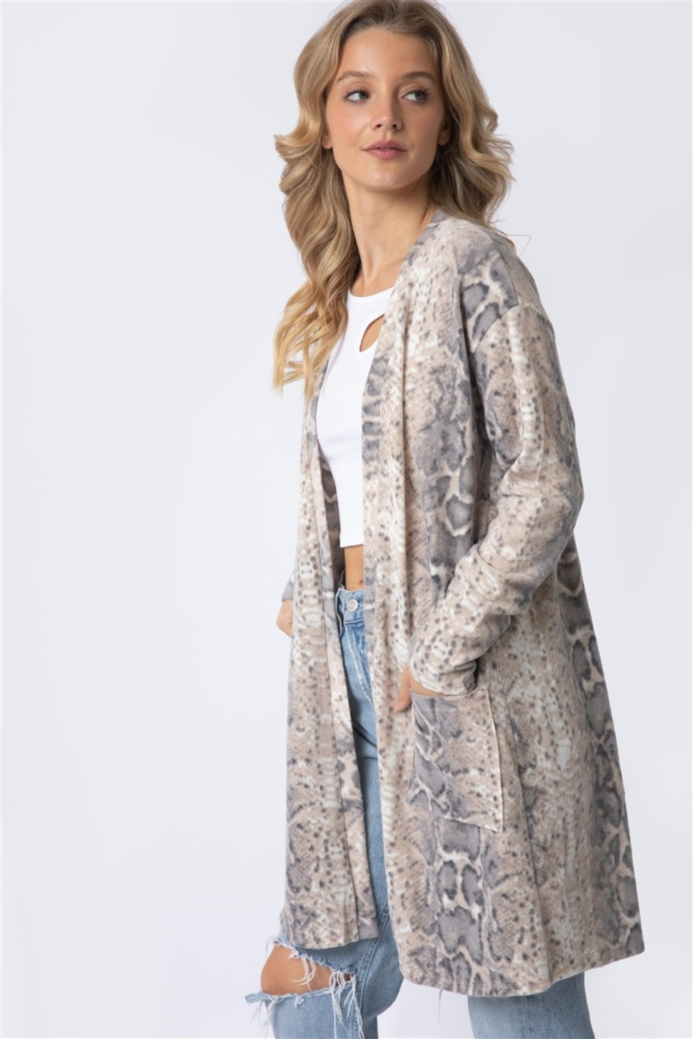 Person wearing a Cherish Apparel Animal Print Flannel Open Front Longline Cardigan with a snake motif, white top, and ripped jeans.