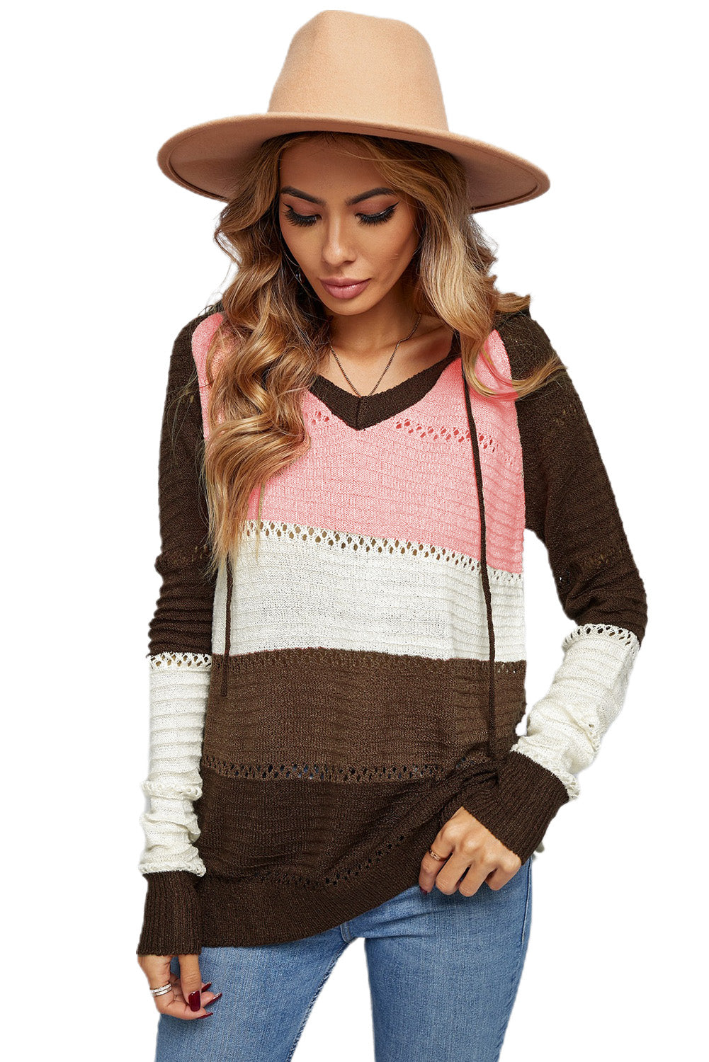 A person stands with their back to the camera, adjusting the hood of a Brown Beach Bonfire Knitted Hoodie featuring dark brown, pink, white, and light brown stripes. Perfect for a casual style, they are wearing distressed blue jeans and showcasing the laid-back vibe of lightweight hoodies.