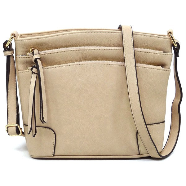 The Fashion Multi Zip Pocket Crossbody Bag is a beige faux leather handbag featuring gold hardware, a front zipper pocket, a two-tone adjustable shoulder strap, and two tassels.