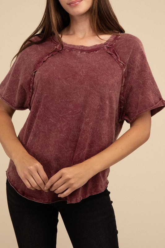 A person with long brown hair wearing a Back Patch Crinkle Washed Raglan Sleeve T-Shirt stands against a plain beige background.