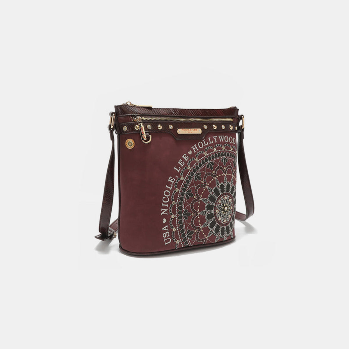 The Nicole Lee USA Metallic Stitching Embroidery Inlaid Rhinestone Crossbody Bag is a brown vegan leather accessory adorned with intricate white designs and text reading "Nicole Lee Hollywood USA" on the front. It features diamond rhinestones, multiple zippered compartments, and an adjustable strap.