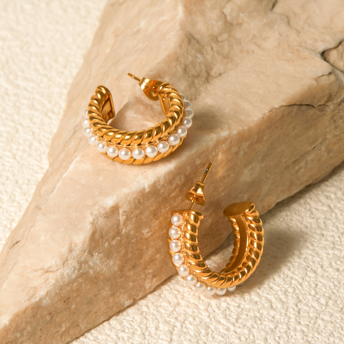 Close-up of a person's ear wearing Stainless Steel Pearl C-Hoop Earrings featuring a row of small synthetic pearls.