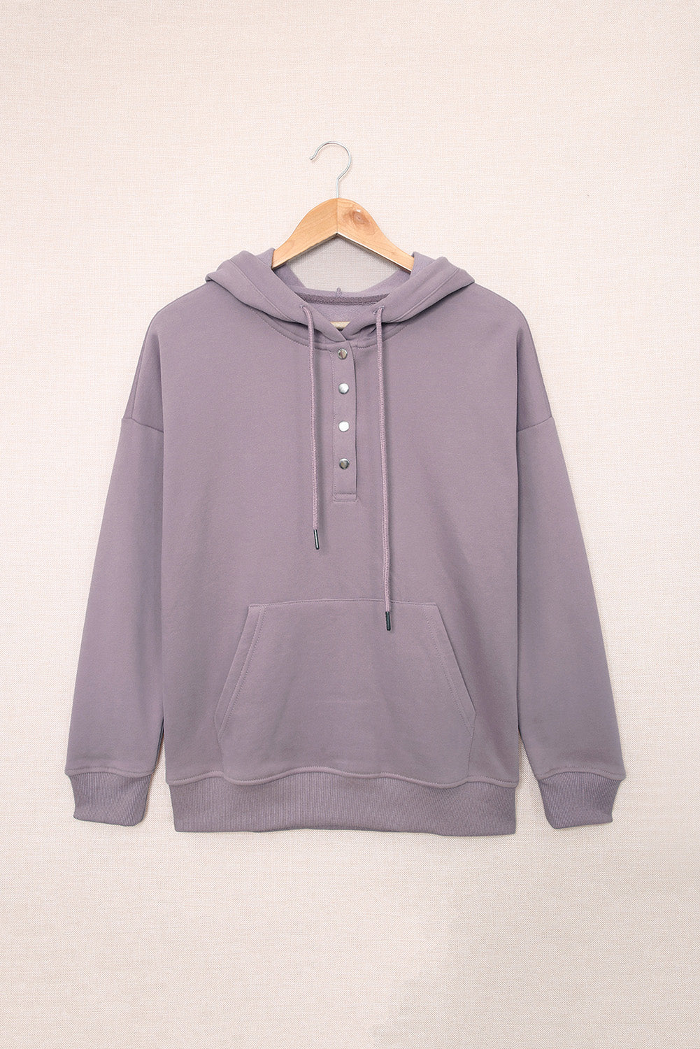 Back view of a person wearing a Purple Snap Button Pullover Hoodie with Pocket and light blue denim shorts with frayed hems, perfect for casual occasions, standing against a grey textured background.