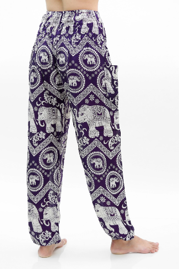 Two views of a person wearing the Purple ELEPHANT Pants: Women Boho Pants Hippie Pants Yoga, showcasing the intricate purple and white elephant patterns. Front and back views are provided to highlight the elastic waist and 100% rayon fabric.