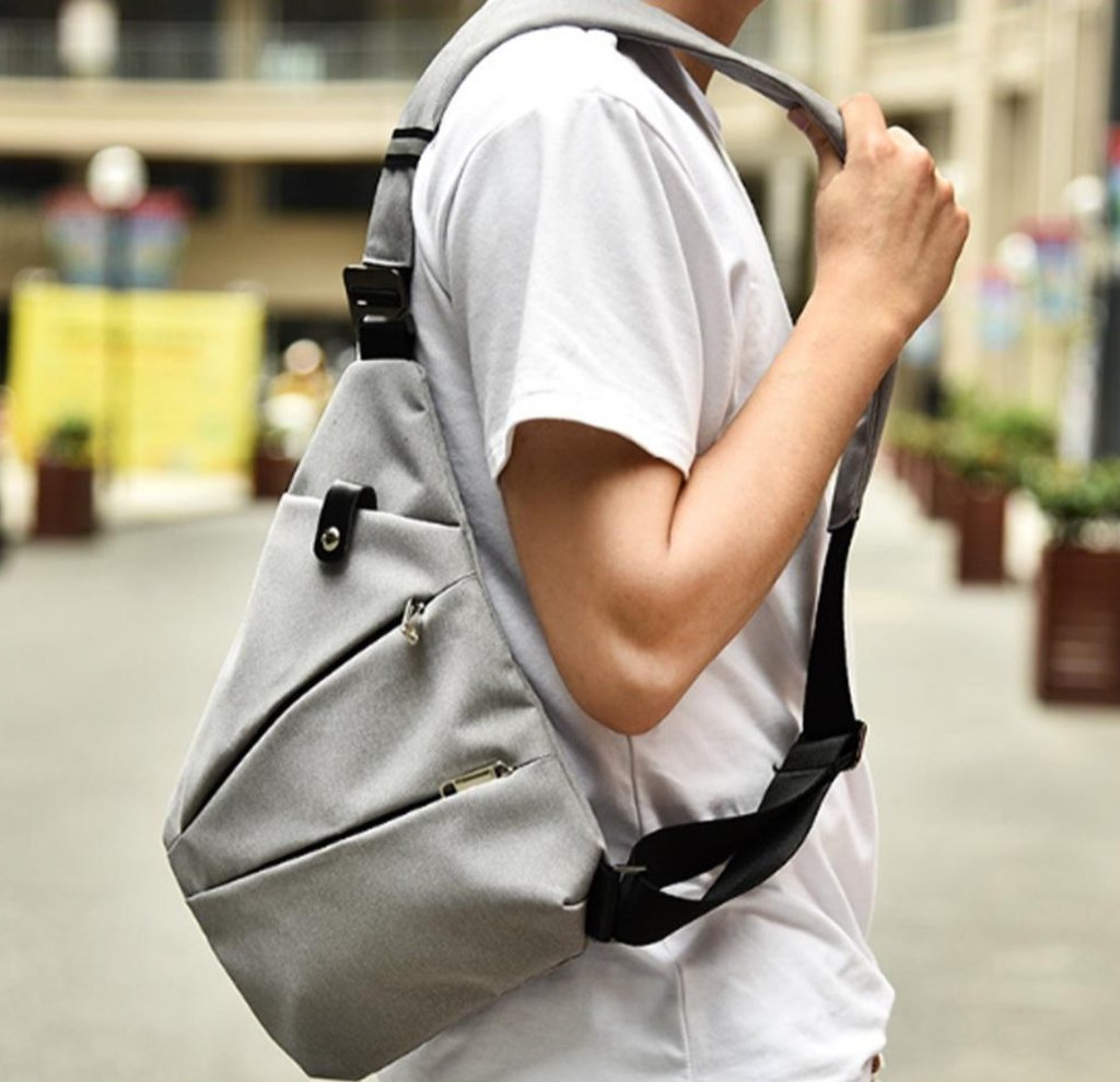 A man wearing a super light, Waterproof Triangle Side Crossbody Bag on the street.