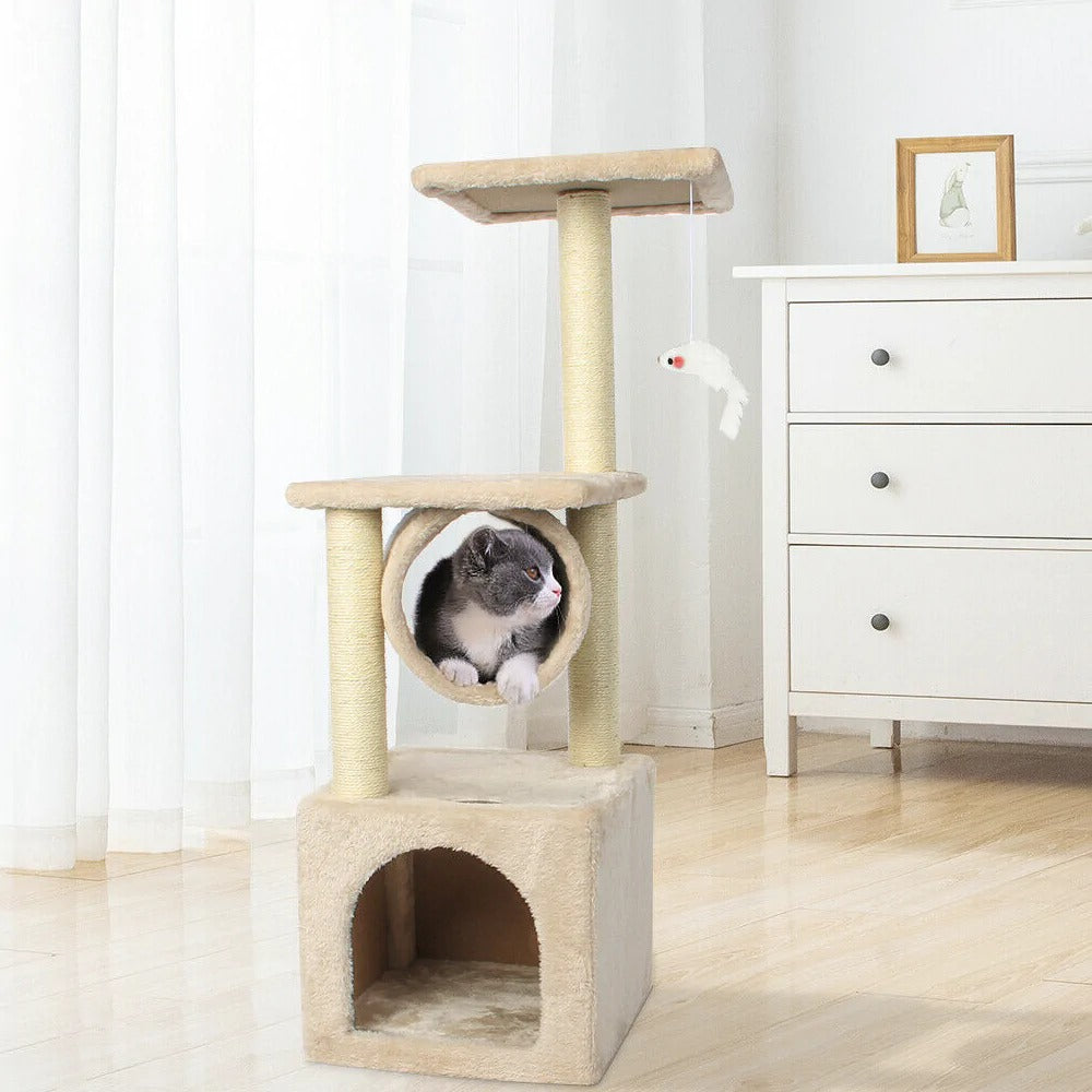 A cat inside the cubby of a Cat Tree House Tower, with a toy fish hanging nearby.