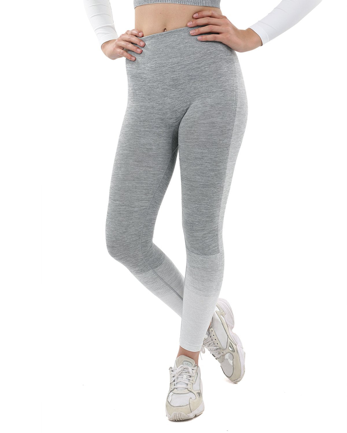 A person showcases Bocana Seamless Leggings in grey & white against a white background, paired with white sneakers.