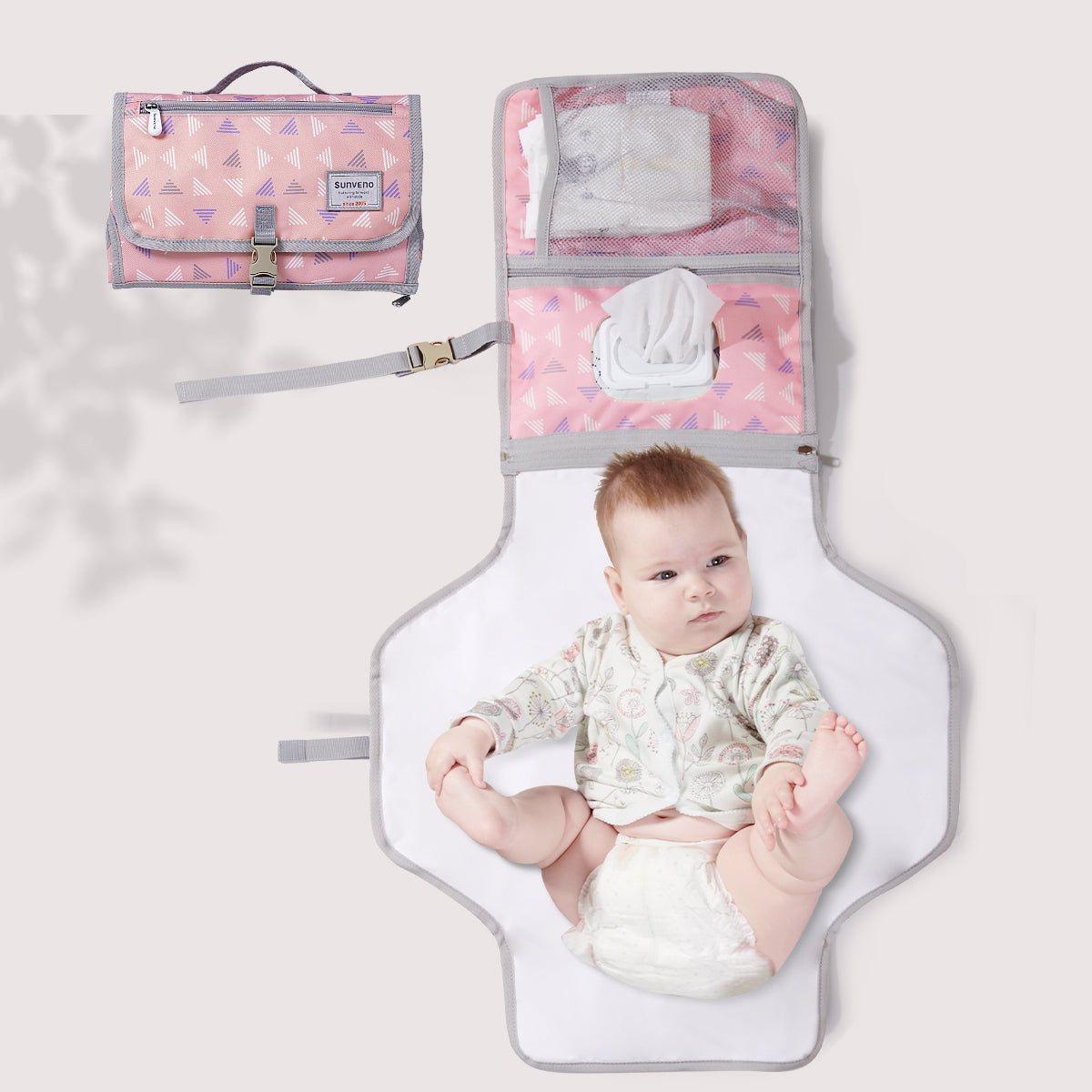 A baby laying on top of a Maroon Chronos Folding Travel Changing Pad.