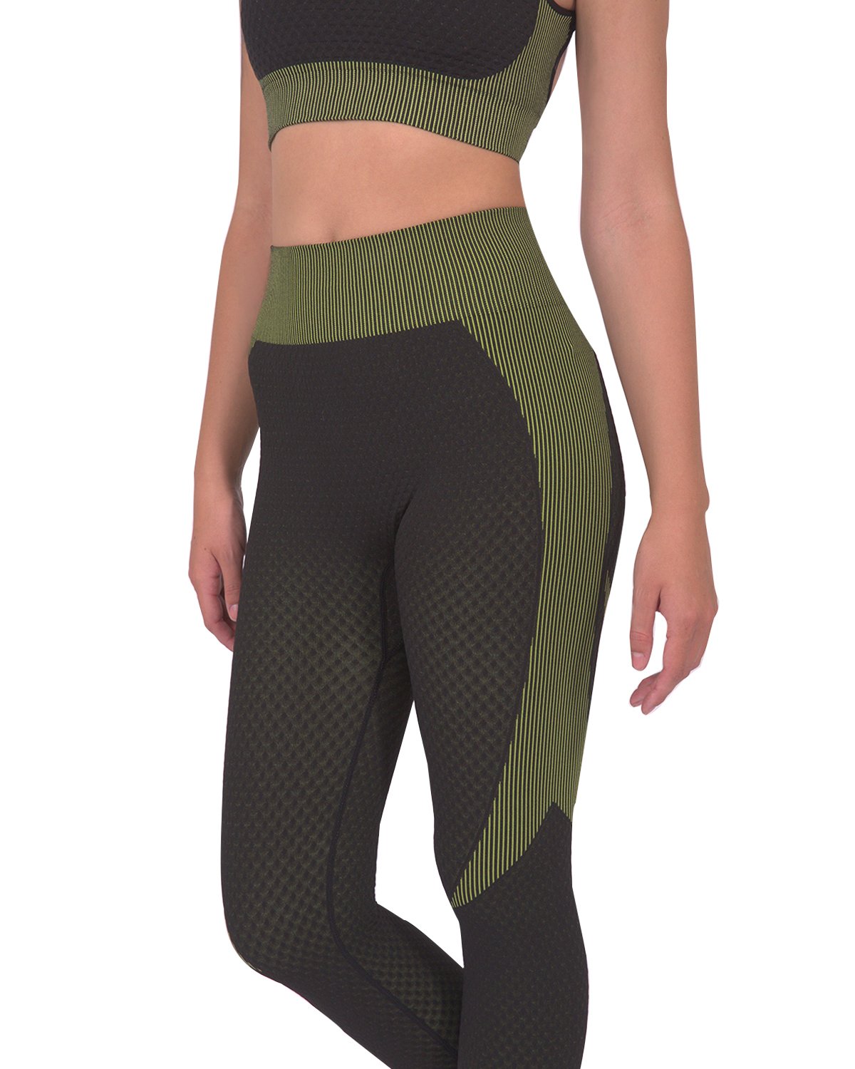 A person is dressed in a green and black athletic outfit, featuring the Trois Two Set. This set includes a sleeveless top paired with high-waisted Trois Seamless Legging - Black with Green, made from high-compression bodycon fabric with a textured pattern. The person's face is not visible in the image.