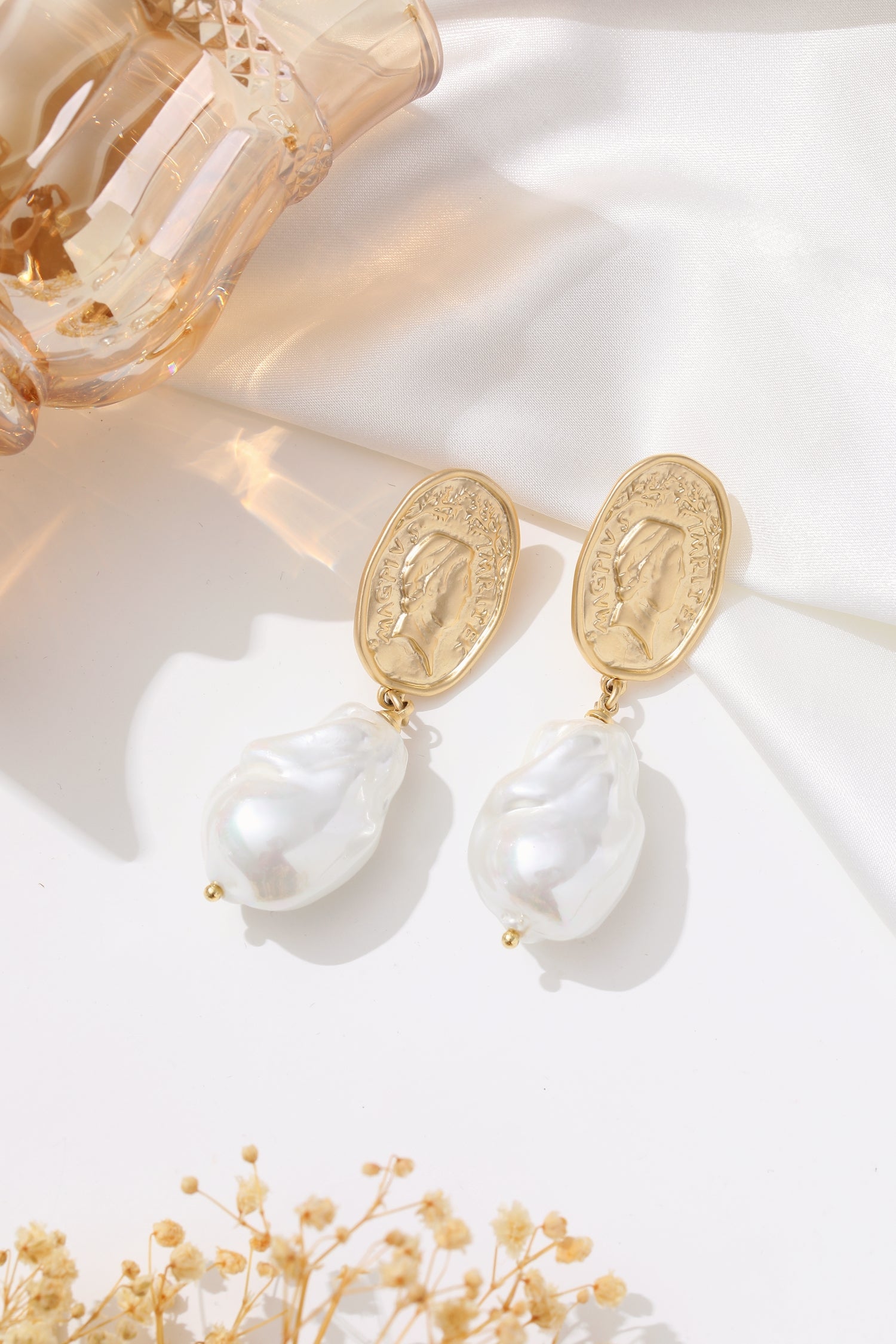 A pair of earrings featuring Matted Gold Sculpted Oversized Baroque Pearl Drop Earrings.