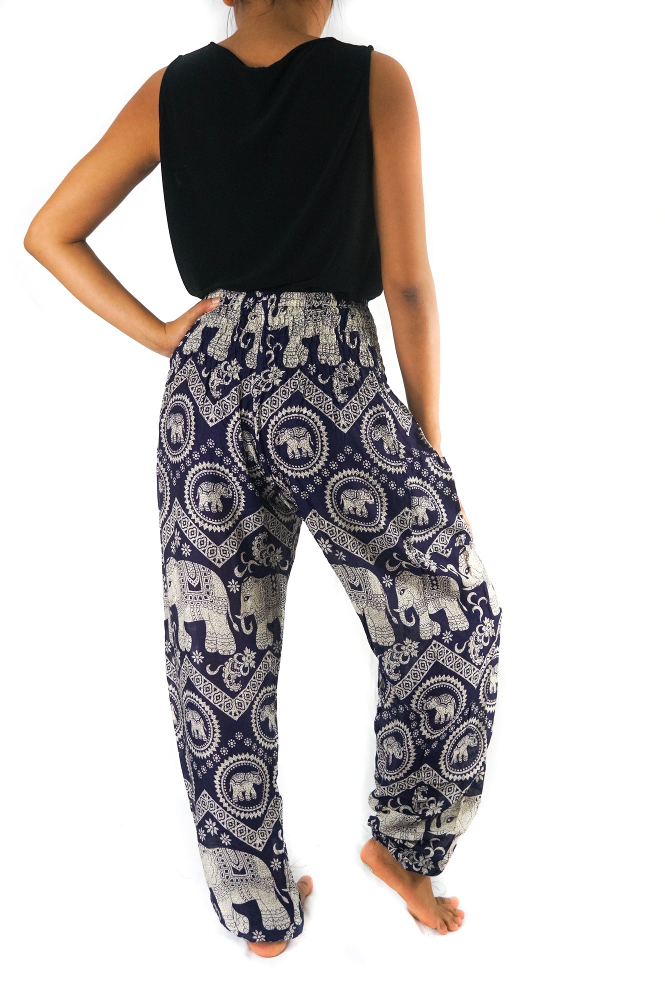 Two views of a person wearing the Purple ELEPHANT Pants: Women Boho Pants Hippie Pants Yoga, showcasing the intricate purple and white elephant patterns. Front and back views are provided to highlight the elastic waist and 100% rayon fabric.