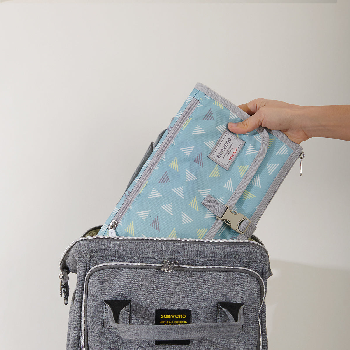 A baby laying on top of a Maroon Chronos Folding Travel Changing Pad.