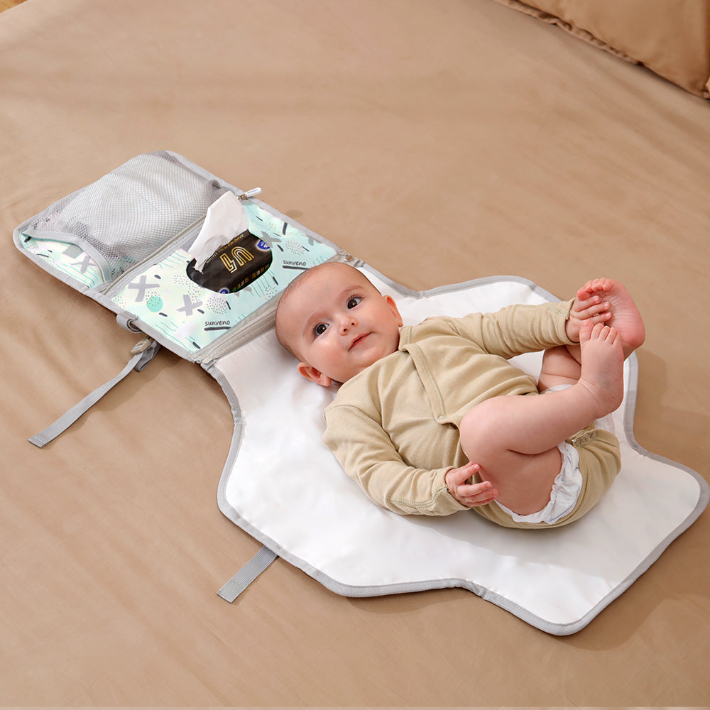 A baby laying on top of a Maroon Chronos Folding Travel Changing Pad.