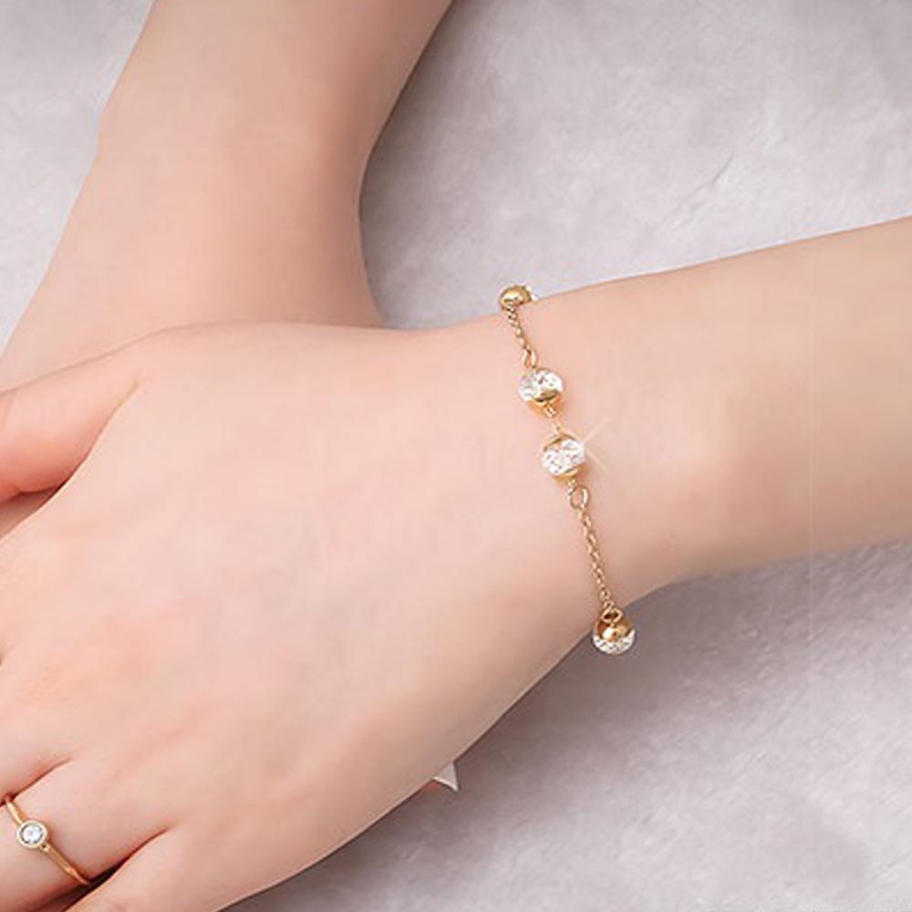A woman's hand adorned with a delicate, Madison 14K Gold Plated Chain Bracelet featuring Swarovski crystals.