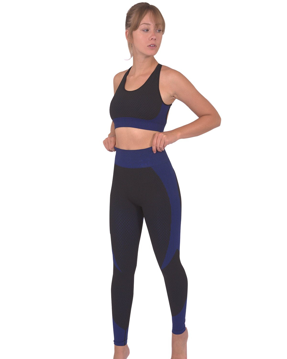 Person in a workout outfit showcasing the back view of Trois Seamless Legging - Black with Navy and a matching sports bra against a white background, highlighting the high-compression bodycon fabric.