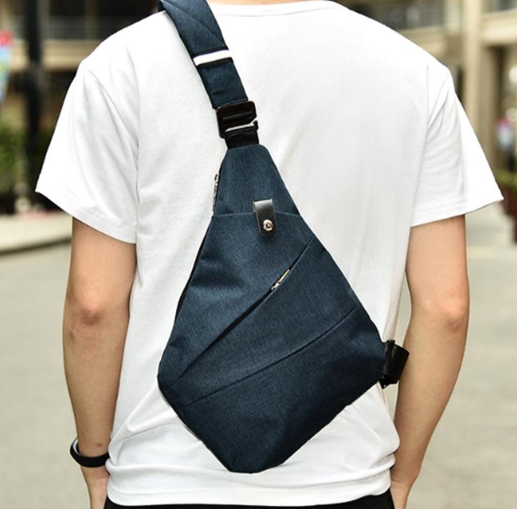 A man wearing a super light, Waterproof Triangle Side Crossbody Bag on the street.