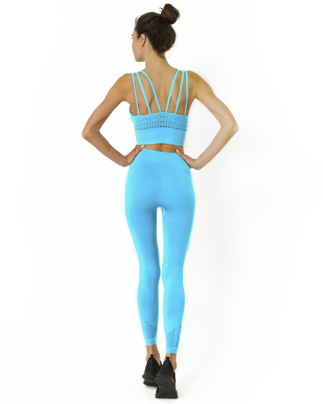 Person wearing the Mesh Seamless Legging with Ribbing Detail in Aqua and black shoes, standing with their back facing the camera against a white background.