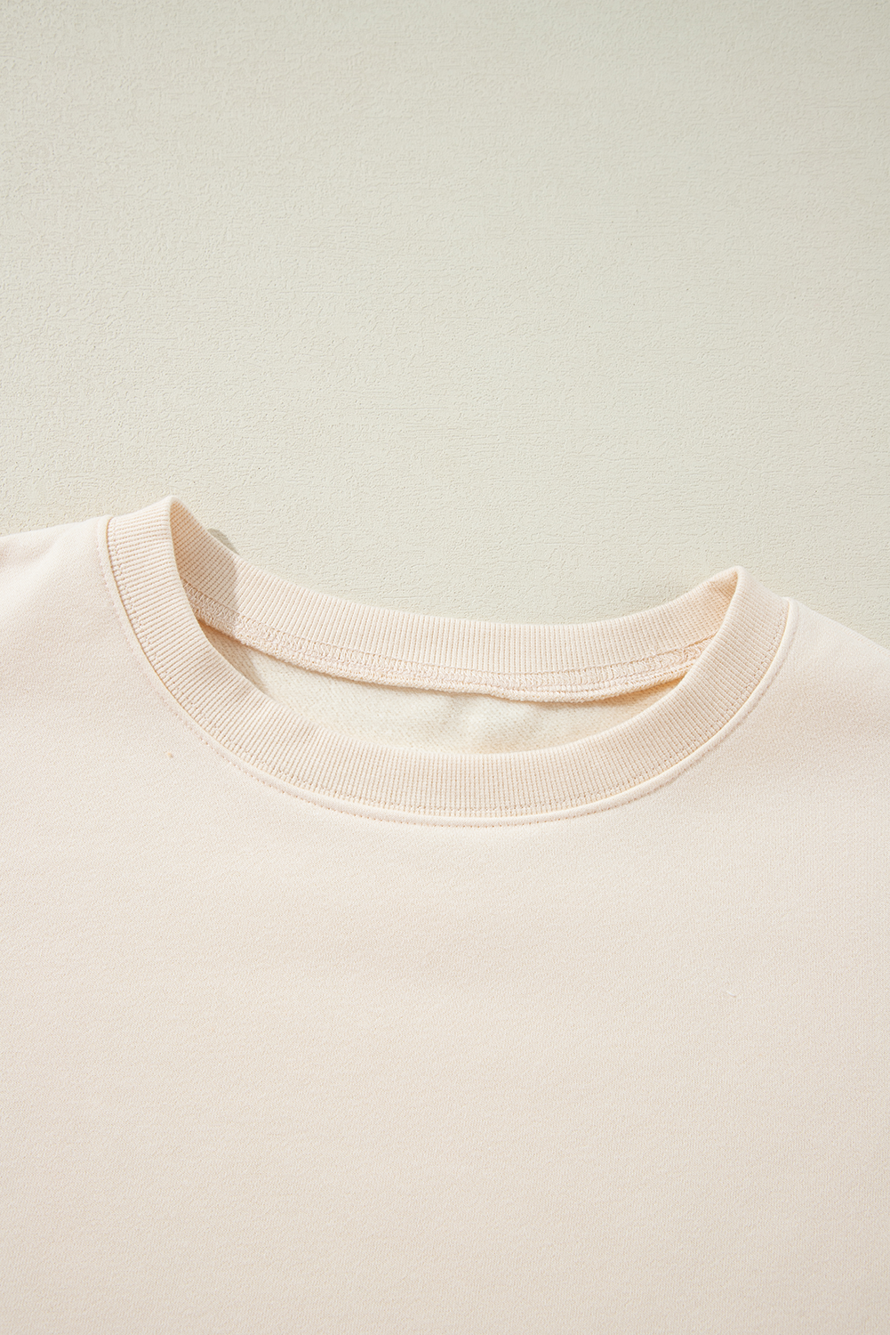 A person with long hair is wearing an Apricot Corduroy Patchwork Drop Shoulder Long Sleeve Sweatshirt, standing with their back to the camera against a light blue corrugated metal wall.