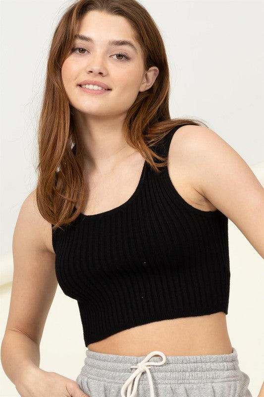 A person with long brown hair smiles while wearing the Perfect Girl Ribbed Open-Back Crop Top in light green, complemented by a delicate necklace.