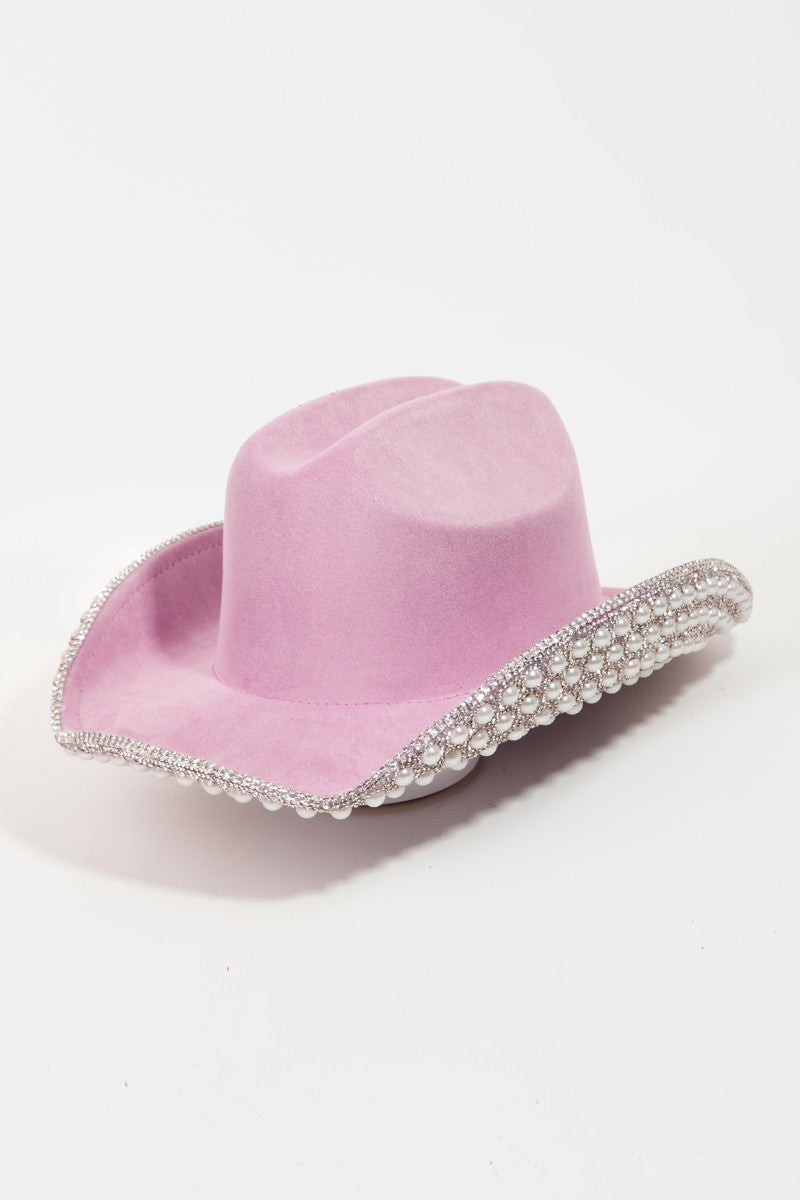 Introducing the Fame Pave Rhinestone Pearl Trim Cowboy Hat: a glamorous Western accessory in light pink, featuring exquisite silver beading along the brim, set against a plain white backdrop.