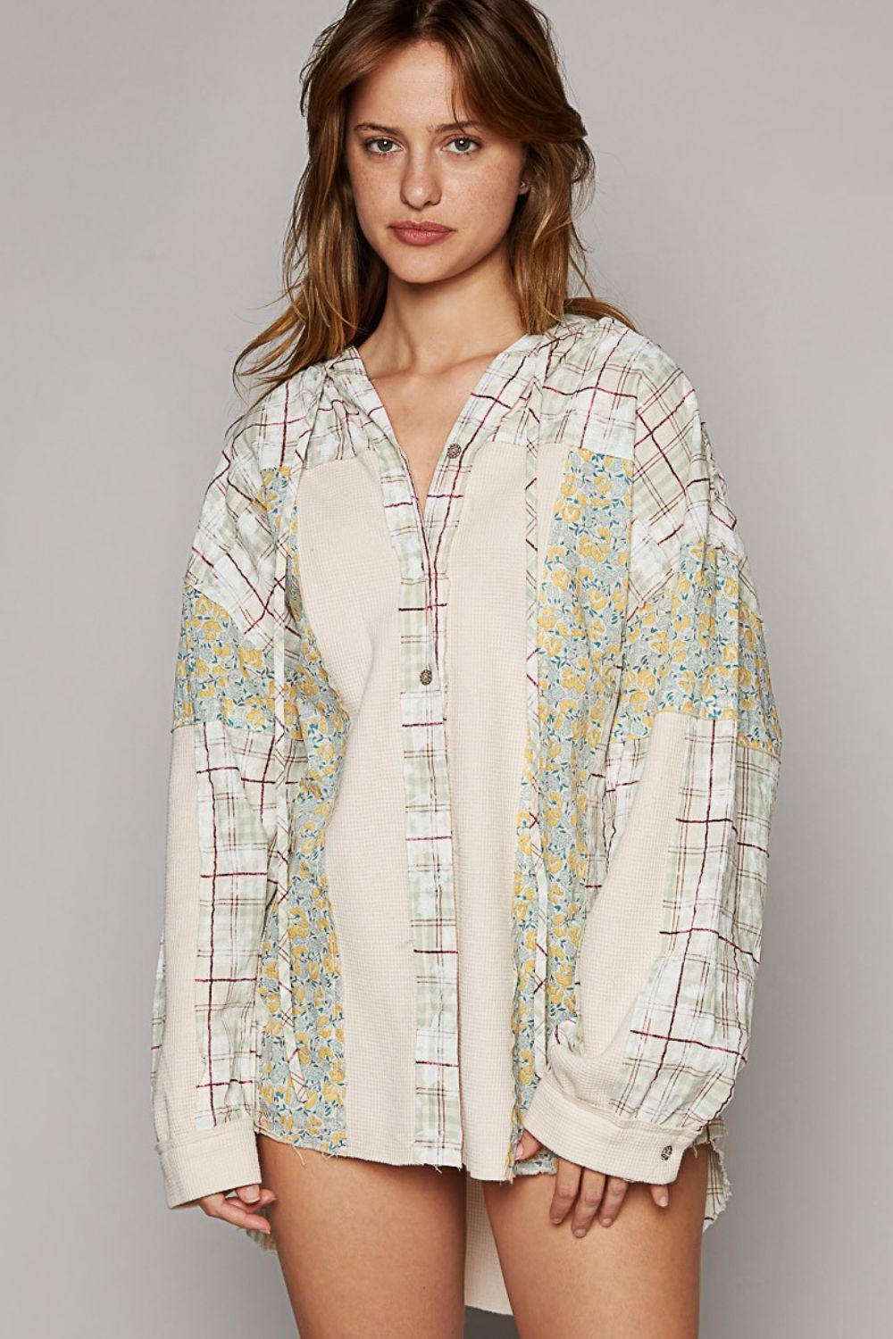 A woman with long hair is wearing a POL Long Sleeve Knit Mixed Hoodie Plaid Shirt featuring plaid patterns and floral accents, standing against a plain background.