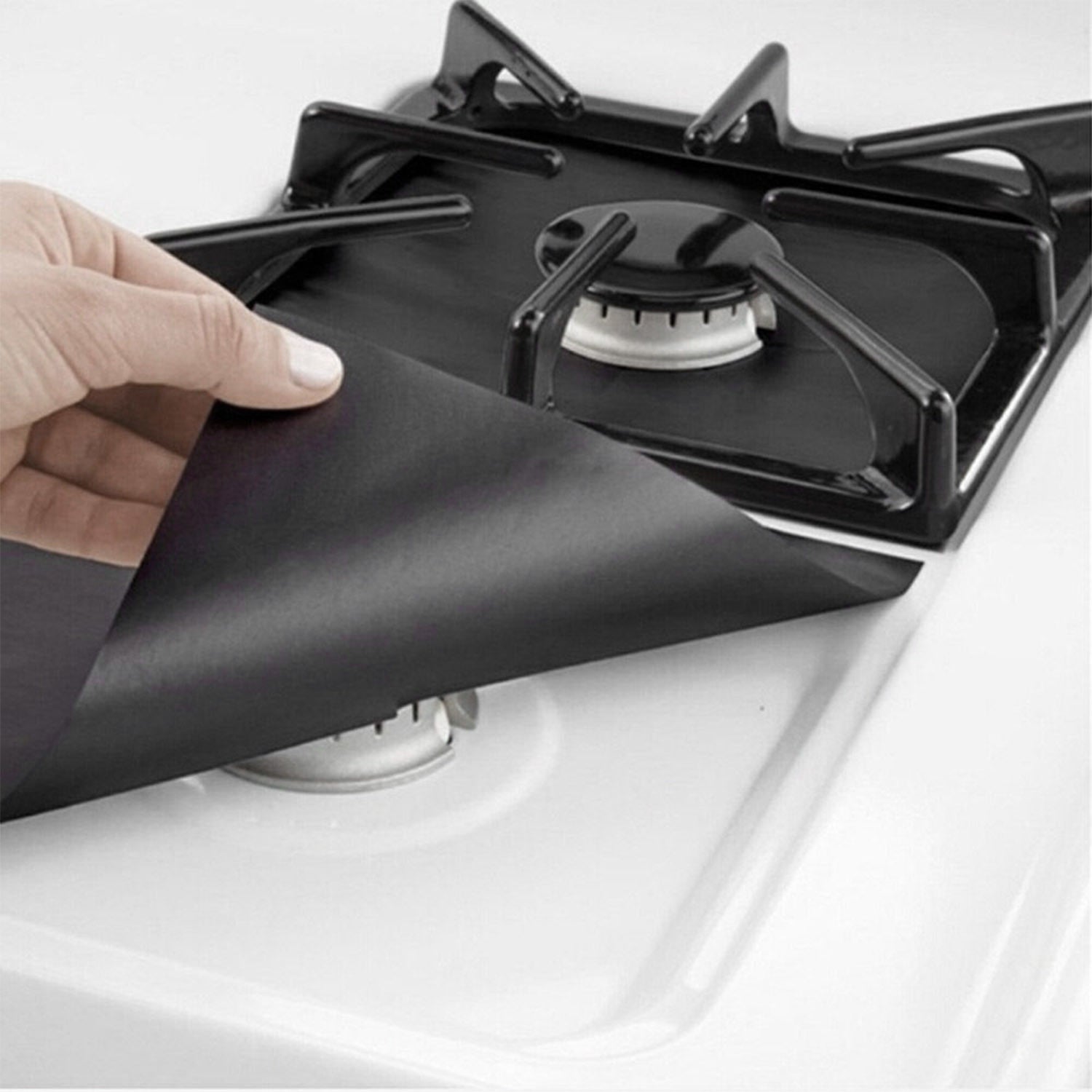 A stack of 4-Pack Reusable Nonstick Stovetop Burner Protector Liner papers with a white circle and crossing lines symbol in the center of the top sheet, treated with a PTFE coating.