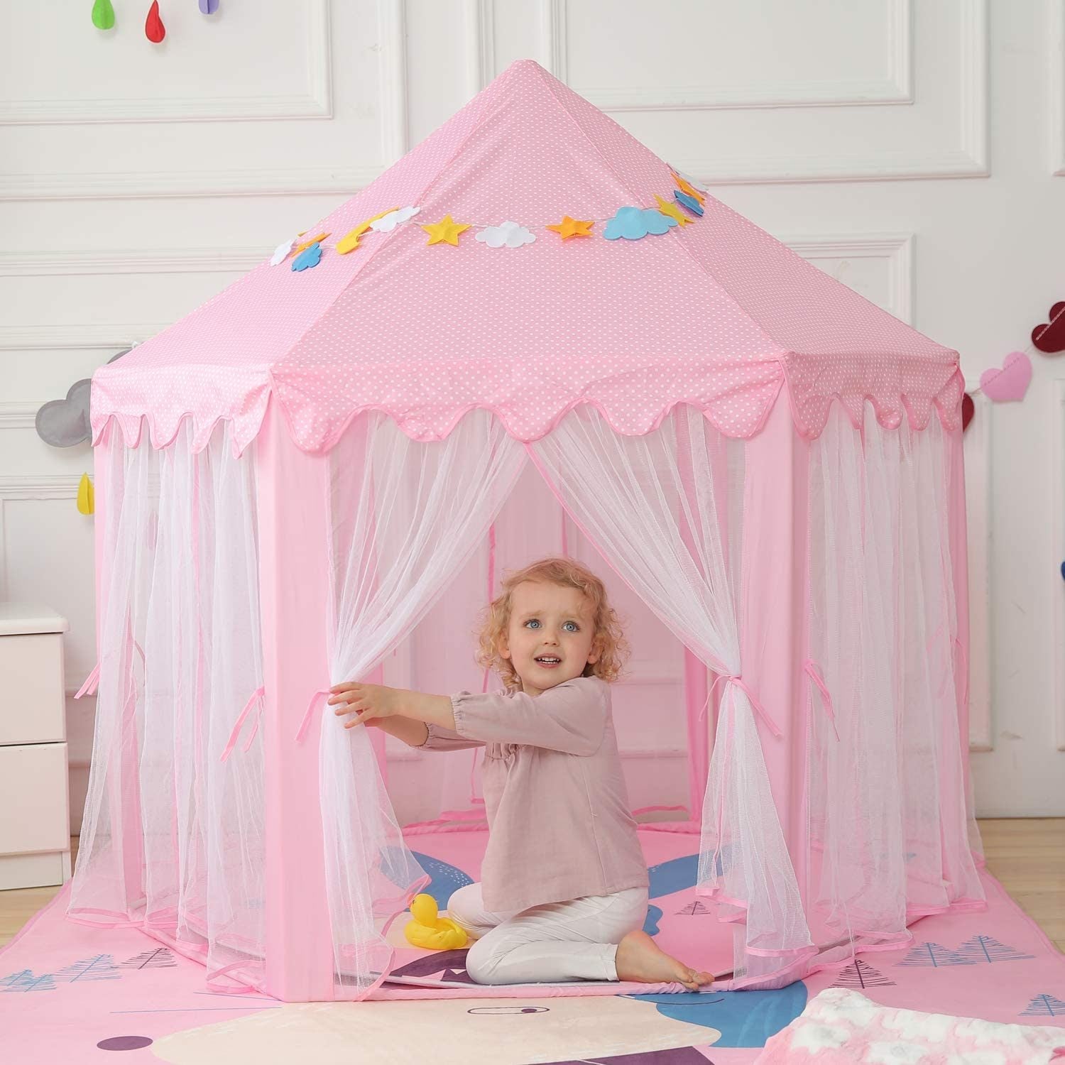 A pink Outdoor Indoor Portable Folding Princess Castle Tent Kids Children Funny Play Fairy House Kids Play Tent with its flap open, displaying several teddy bears inside, illuminated by string lights, with a star-shaped light visible at the top corner.