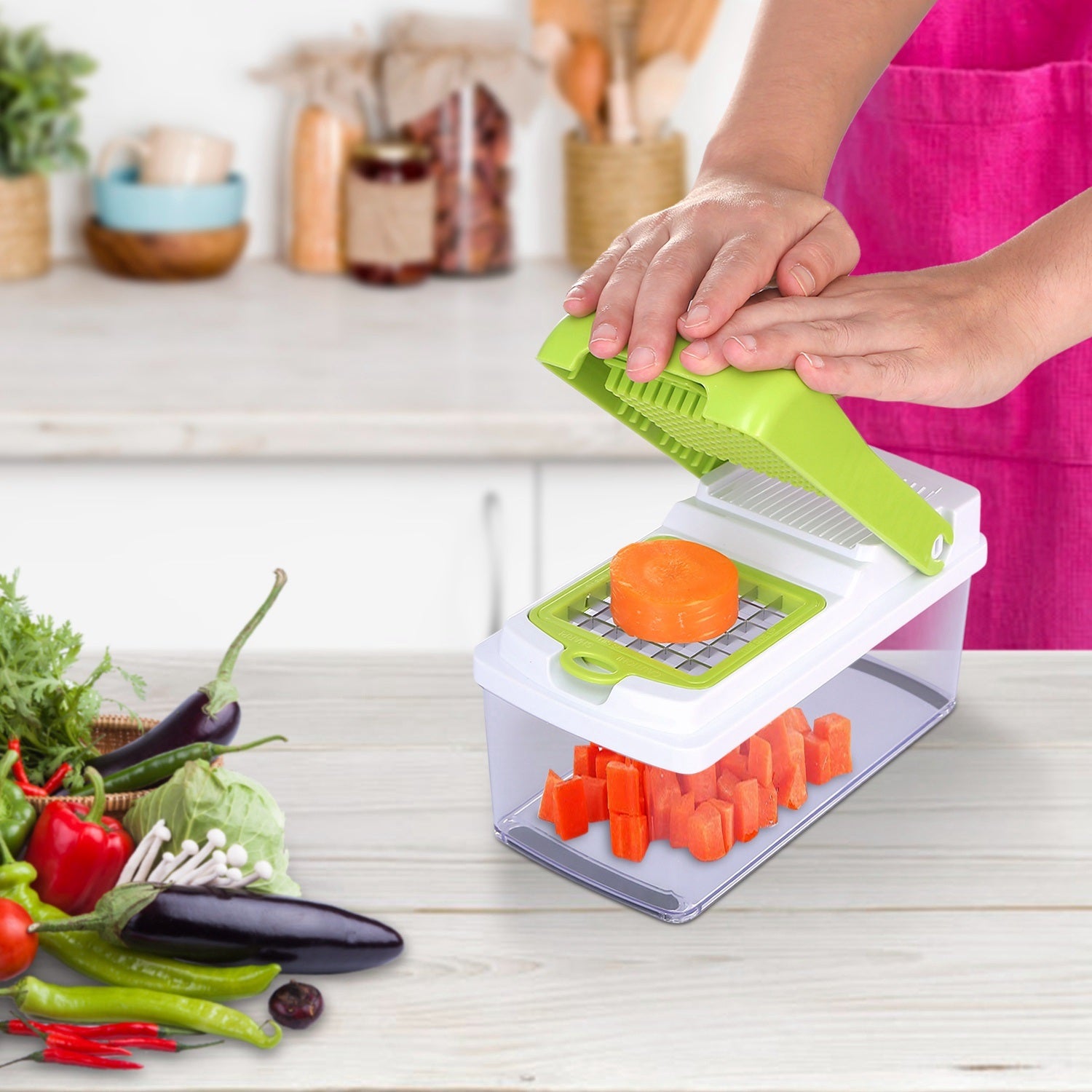A Vegetable Slicer Quick Potato Tomato Fruit Cutter Set with 3 Blades Stainless Steel Food Chopper with sliced carrots inside it, placed on a kitchen counter with tomatoes nearby.