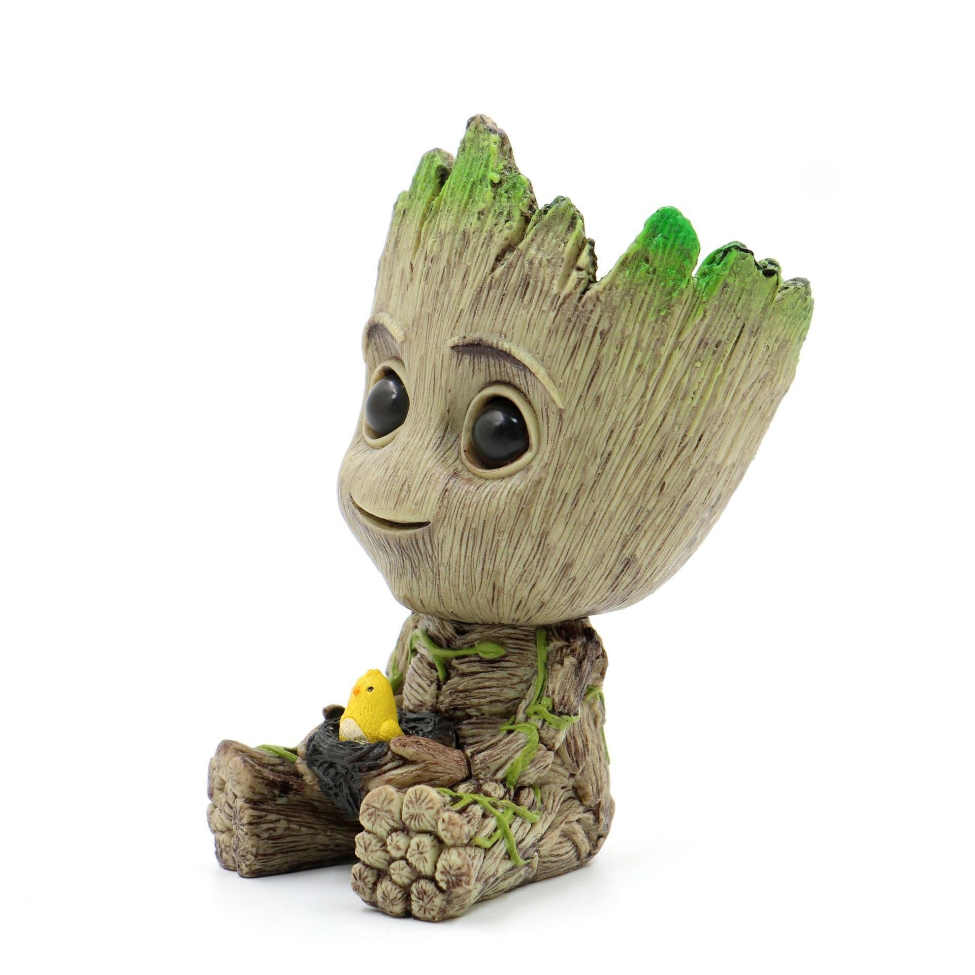 A Guardians of the Galaxy Groot Tree Man Hand Ornament, crafted from PVC, holding a small bird, with green leaves sprouting from its head, isolated on a white background.