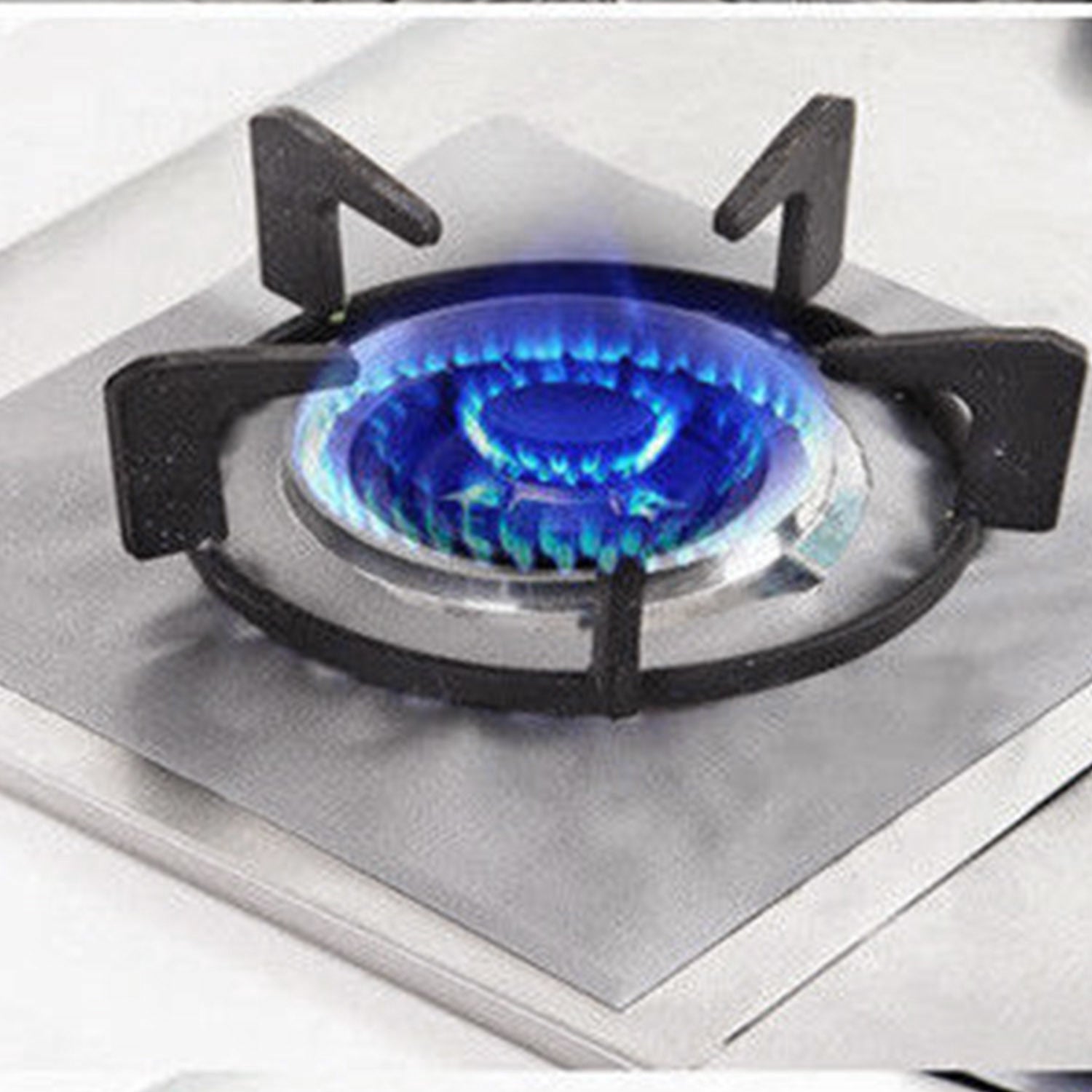 A stack of 4-Pack Reusable Nonstick Stovetop Burner Protector Liner papers with a white circle and crossing lines symbol in the center of the top sheet, treated with a PTFE coating.