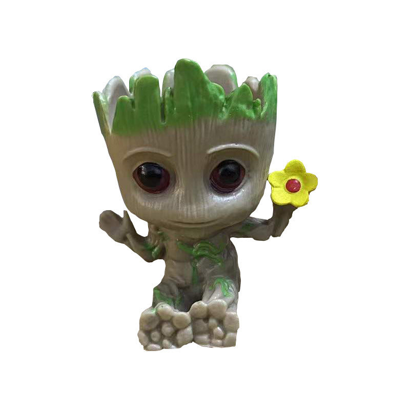 A Guardians of the Galaxy Groot Tree Man Hand Ornament, crafted from PVC, holding a small bird, with green leaves sprouting from its head, isolated on a white background.