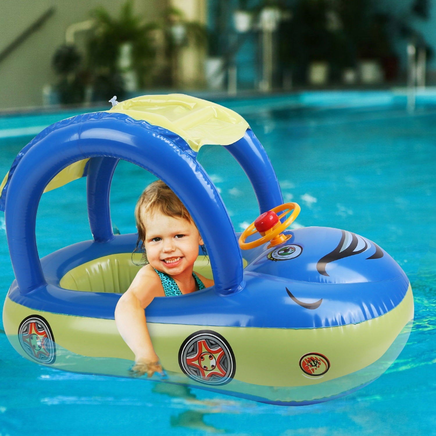 A young child smiles while sitting in a colorful Baby Inflatable Pool Float Car Shaped Toddler Swimming Float Boat Pool Toy Infant Swim Ring Pool with Sun Protection Canopy for 1-3 Year-Old Kids Infant Toddlers in a swimming pool.