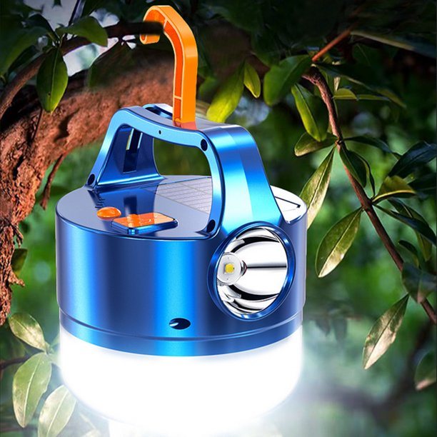 A blue 3N1 Solar Lantern With Remote hanging from a tree branch in a forest setting, ideal for outdoor adventures.
